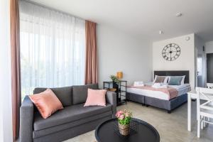 a living room with a couch and a bed at Apartamenty Bellamaya - Kapitanska 8 in Grzybowo
