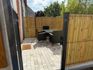 a patio with a table and chairs and a fence at Le 122 , maison climatisée avec jardin in Romorantin