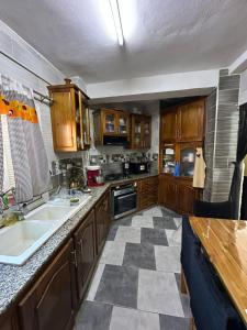 a kitchen with wooden cabinets and a checkered floor at Évasion Marine - Plage & Attractions à 5 Min in Mostaganem