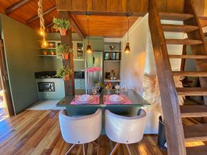 a dining room and kitchen with a table and chairs at Cabana com visual incrível para a Serra in Timbe do Sul +29 photos