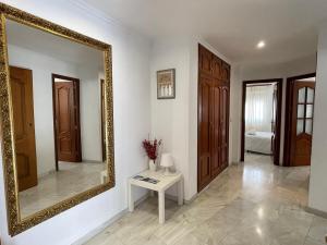 uno specchio a parete in una stanza con tavolo di Apartamento CAMINO MOZÁRABE a Doña Mencía