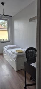 a bedroom with a bed and a chair and a window at Mieszkanie Borneo in Borne Sulinowo
