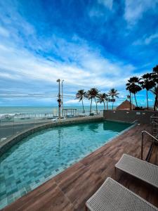 a swimming pool with the ocean in the background at Residencial Loft - Studio -407 in Maceió