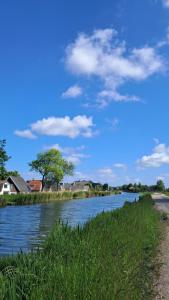 a view of a river with houses and buildings at Bell-tent Luna met uitzicht in Hensbroek