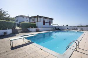 una piscina en un patio con una casa en Maison Beltzenia, en Urrugne