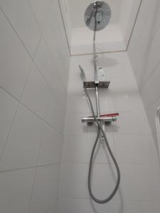 a shower in a white tiled bathroom with a shower head at Casa Fiorenza - Da e Nònne in Carloforte +47 photos