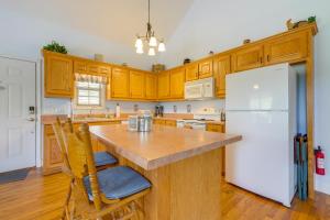 a kitchen with wooden cabinets and a white refrigerator at 3 Mi to Hiawassee Berry Cute Country Cottage in Hiawassee