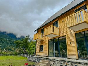 a log house with a balcony and windows at Fryma e Bjeshkeve in Theth