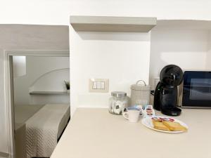 a kitchen counter with a plate of bread and coffee at CasUccia, nel cuore del centro storico di Gallipoli in Gallipoli