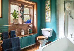 a bathroom with a toilet and a bath tub at Historic Hidden Gem-10mins walk to Holmfirth, Log Burner,Easy Parking in Holmfirth