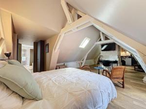 an attic bedroom with a bed and a living room at Le Clos Guivet in Troyes