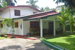 a white house with a red roof at CFC Holiday Home in Anuradhapura