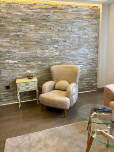 a living room with a chair and a table at smgold lux apartman in Podgorica