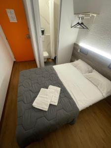 a bedroom with a bed with two towels on it at HOTEL THANIA Sète Frontignan in Frontignan
