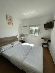 a bedroom with a large white bed and a window at HOTEL THANIA Sète Frontignan in Frontignan +34 photos
