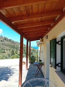 a patio with a wooden pergola and a table at Κυκλαδίτικο σπίτι in Andros