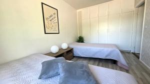 a bedroom with two beds and a picture on the wall at Villa Ruths Stay Vegas in Kouvola