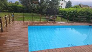 a large blue swimming pool next to a fence at Villa Cresto in Gaglianico