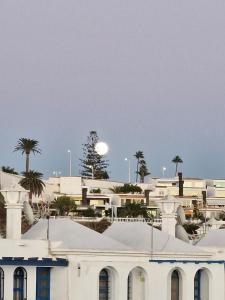 a white building with palm trees in the background at Bungalow Faro y Dunas Maspalomas in Maspalomas