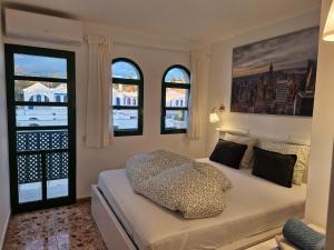 a bedroom with a bed with three windows at Bungalow Faro y Dunas Maspalomas in Maspalomas