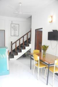 a dining room with a table and chairs and a staircase at CFC Holiday Home in Anuradhapura