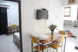 a dining room with a table and a tv on a wall at CFC Holiday Home in Anuradhapura