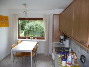 a kitchen with a white table and a window at Wohnung Kattenwarft EG in Böhl