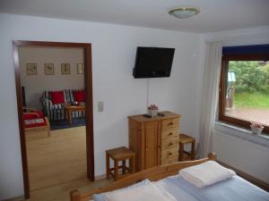 a bedroom with a bed and a television on a wall at Wohnung Kattenwarft EG in Böhl