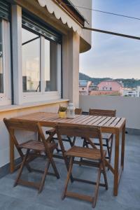 una mesa de madera y sillas en un patio con ventana en Artemisia, en Sestri Levante