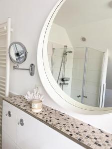 a bathroom with a large mirror and a counter at Haus Lieblingsquartier in Tating
