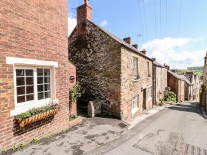 an old brick building with a window on a street at The Beehive in Matlock