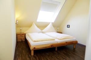 a bedroom with a large bed with a skylight at Haus Schimmelreiter in St. Peter-Ording