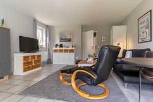 - un salon avec une chaise noire et une table dans l'établissement Auszeit unter Reet, à Böhl