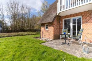 une maison en briques avec une table et des chaises dans la cour dans l'établissement Auszeit unter Reet, à Böhl