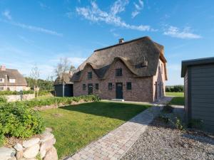 an old brick house with a thatched roof at Hochdorfer Garten in Tating