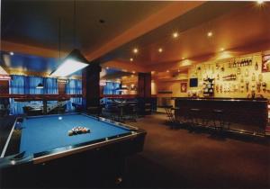 une salle avec un billard et un bar dans l'établissement Hotel Uno, à Kecskemét