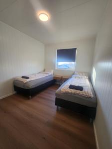 two beds in a small room with a window at Private 4 bedroom getaway in Lofoten in Vestvågøya