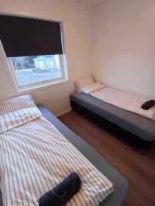 two beds in a small room with a window at Private 4 bedroom getaway in Lofoten in Vestvågøya +16 photos