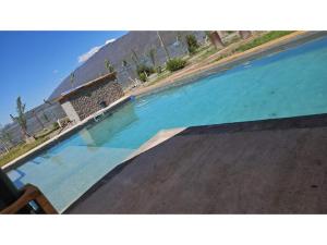 a large swimming pool with blue water at Casa en Zonda in Zonda