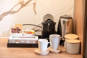 a coffee maker and cups on a table at Sandy'sLuxuryApartment in Alexandroupoli