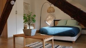 セレスタにあるLe duplex des Marchandsのベッドルーム1室(ベッド1台、鉢植えのテーブル付)