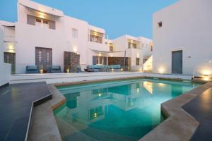 a swimming pool in a villa with a house at Villa Kelly Rooms & Suites in Naousa