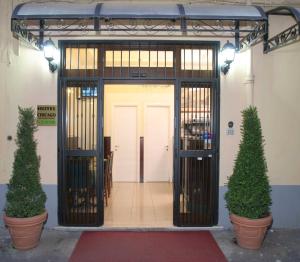 an open door with two potted trees in front of it at Hotel Chicago in Rome