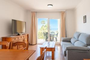 a living room with a couch and a tv at Apartamentos Solset Nerja in Nerja