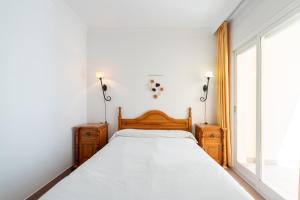 a bedroom with a bed and a large window at Apartamentos Solset Nerja in Nerja