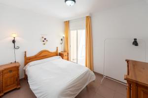 a bedroom with a white bed and a window at Apartamentos Solset Nerja in Nerja