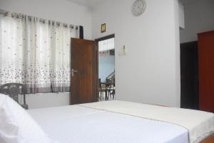 een slaapkamer met een bed, een raam en een tafel bij Vishaka Holiday Home in Anuradhapura