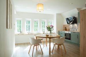 a kitchen with a table and chairs in a room at Fewo Eickhorst in Menslage