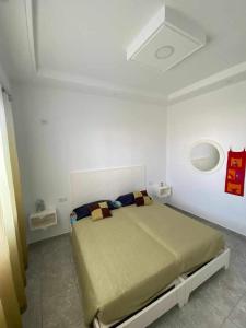 a bedroom with a bed in a white room at Ain grenz2 kelibia in Kelibia