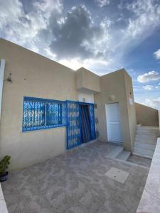 a house with a blue window and a door at Ain grenz2 kelibia in Kelibia +8 photos